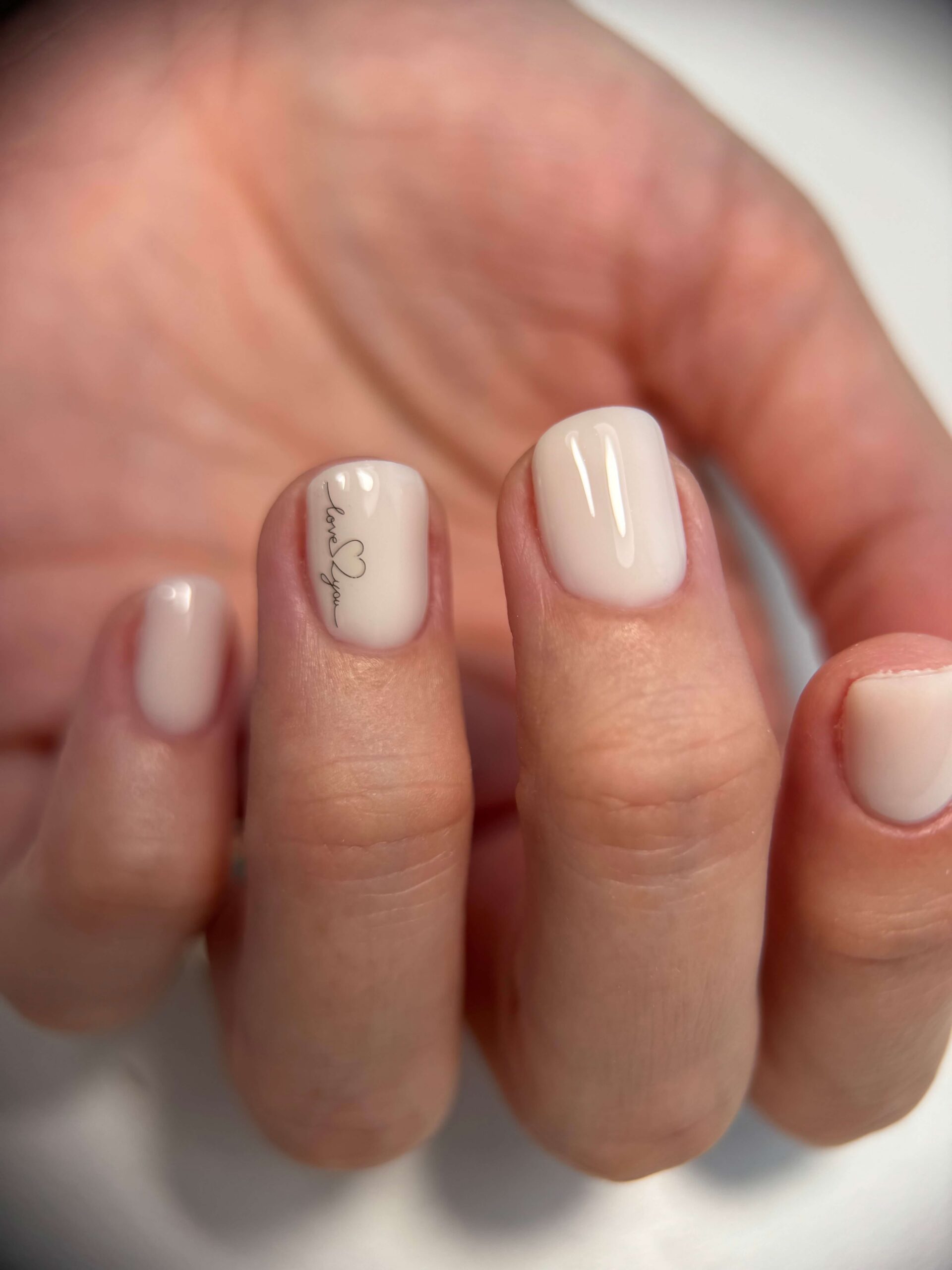 Minimalistická milky krémová manikúra s jemným nápisom - Urban Beauty Pezinok